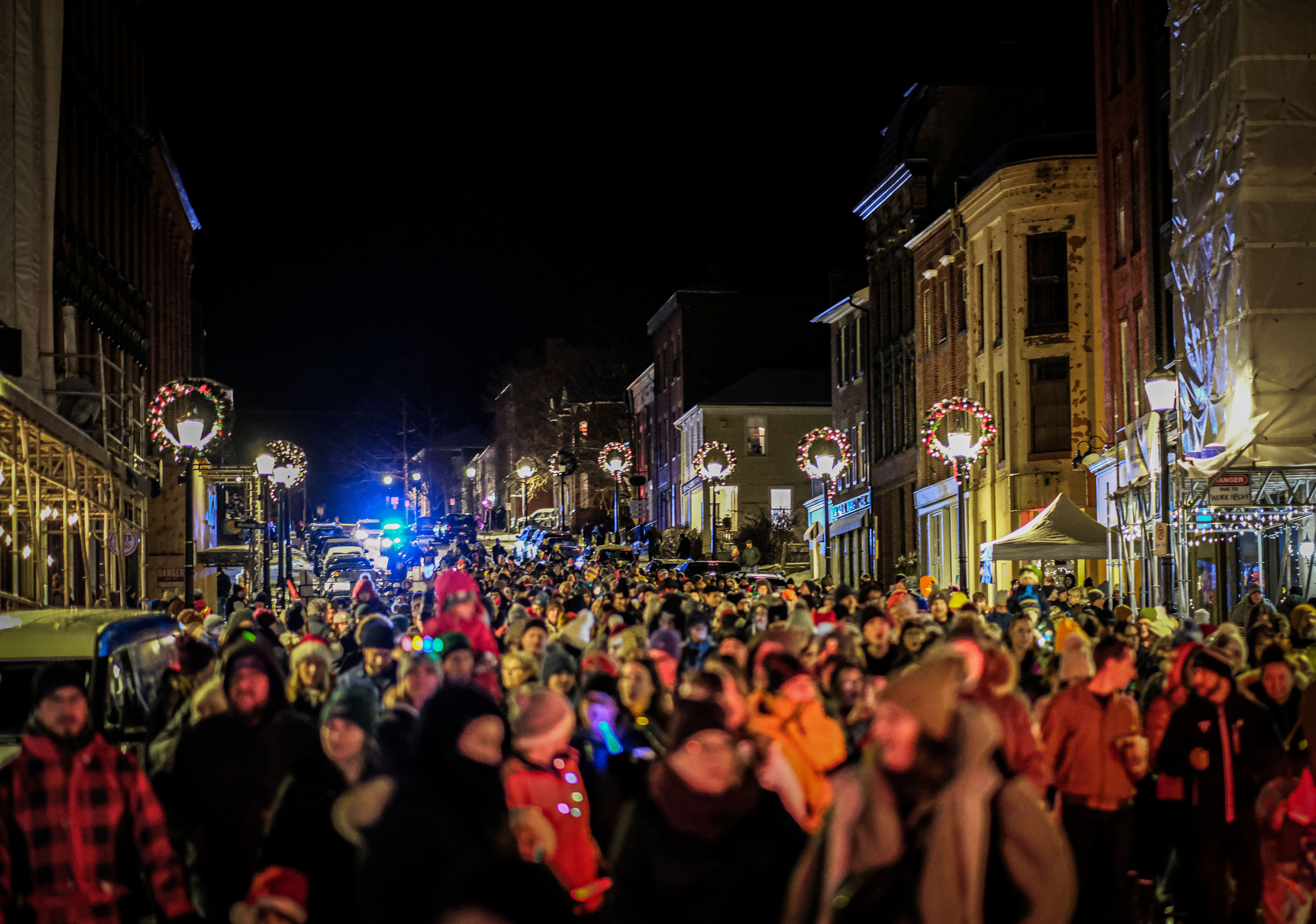 Image of a small town's downtown full of people walking around during a holiday festival