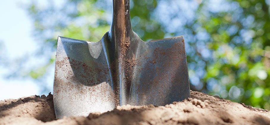 A shovel digging into dirt