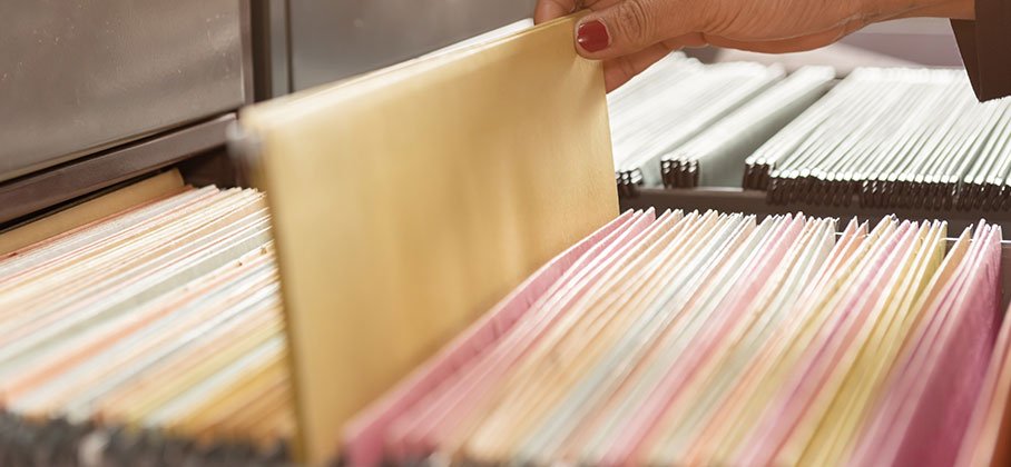 A hand pulling a file out of drawer