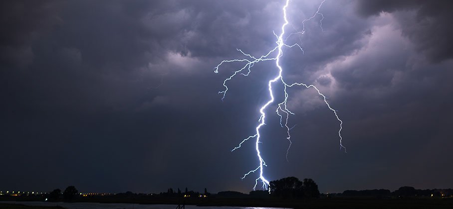 lighting striking in a field 