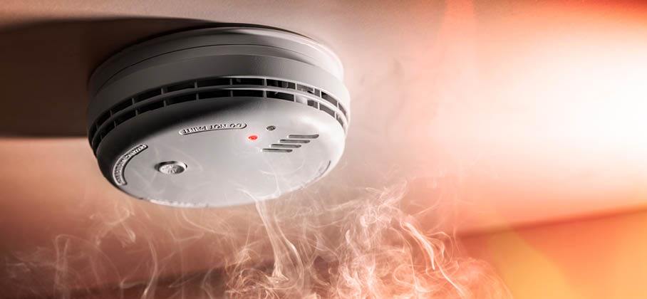 Image of a smoke alarm with smoke surrounding it