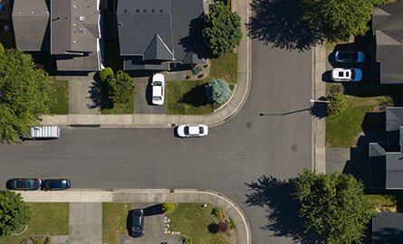 Aerial view of a subdivision with cars parked on the road