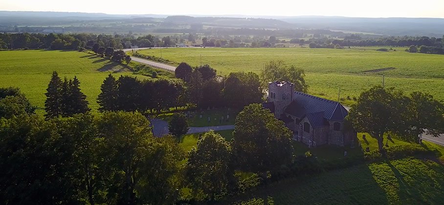 Arial shot of stone church and farmers fields