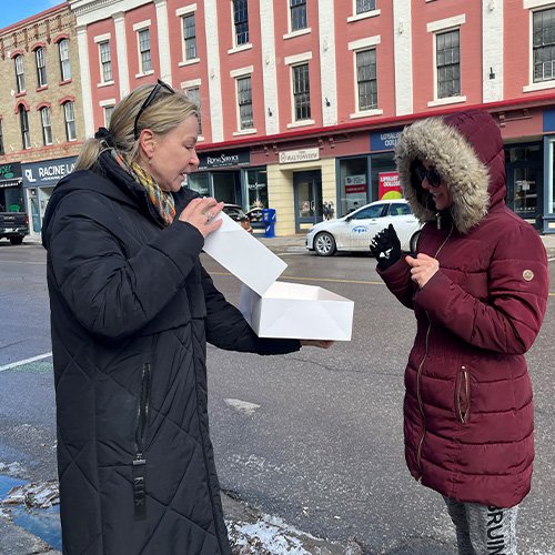 two women with white cupcake box