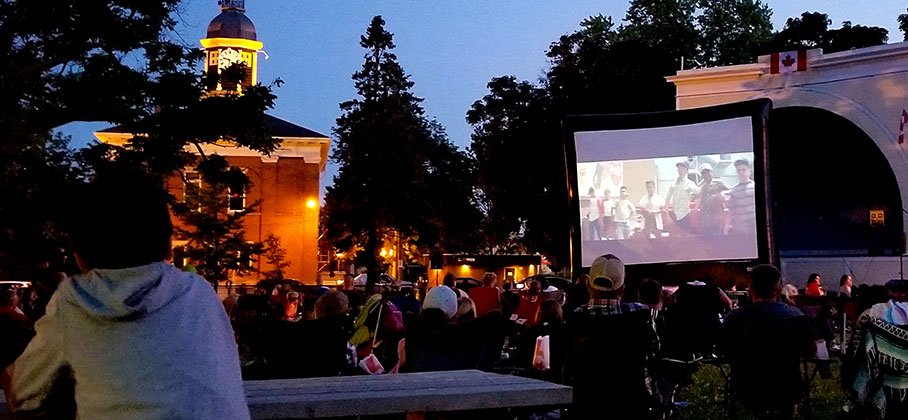 People watching a movie around the bandshell