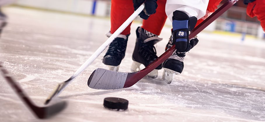Hockey stick handling a puck on the ice