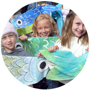 Children holding their fish paintings