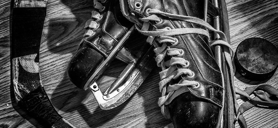 Vintage photo of a skate, hockey stick and puck
