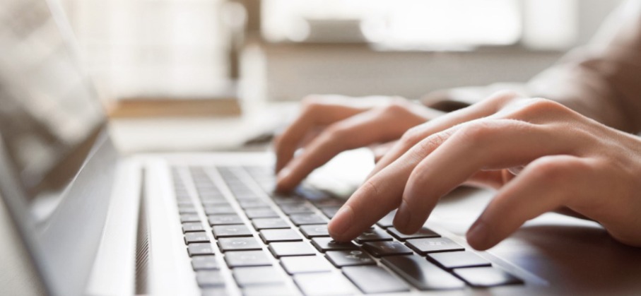 close up of hands typing on a laptop