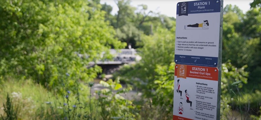 Two outdoor signs on the fitness loop trail