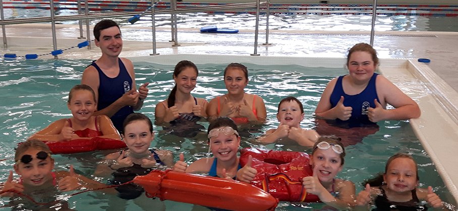 Group of kids and swim instructors