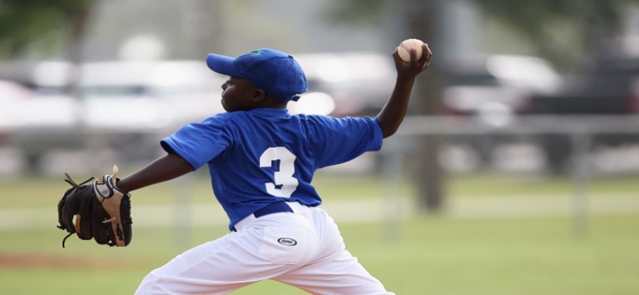 boy in baseball uniform prepared to pitch a baseball