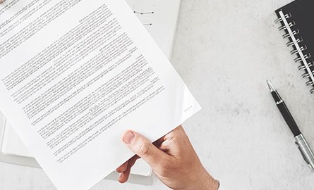 Person passing papers on a desk