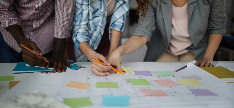 People working together on plans with different colour sticky notes